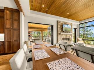 Experience luxury mountain living in this stunning home featuring a spacious dining area with a rustic wooden table and elegant placemats.