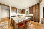 Experience luxury in this stunning modern kitchen, featuring rich wood cabinetry and a sleek marble island perfect for entertaining.