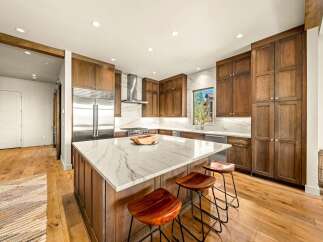 Experience luxury in this stunning modern kitchen, featuring rich wood cabinetry and a sleek marble island perfect for entertaining.