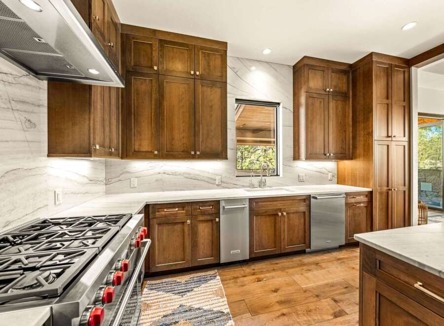 Experience luxury in this stunning kitchen, featuring custom wood cabinetry and sleek marble countertops.