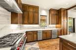 Experience luxury in this stunning kitchen, featuring custom wood cabinetry and sleek marble countertops.