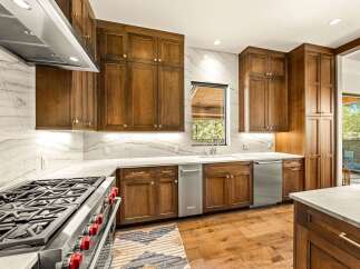 Experience luxury in this stunning kitchen, featuring custom wood cabinetry and sleek marble countertops.