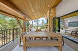 Experience luxurious indoor-outdoor living with this stunning covered patio, featuring a spacious dining area and a cozy seating space with a fireplace.