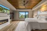 Experience luxury mountain living in this stunning bedroom featuring a modern gas fireplace and a wall-mounted television for ultimate relaxation.
