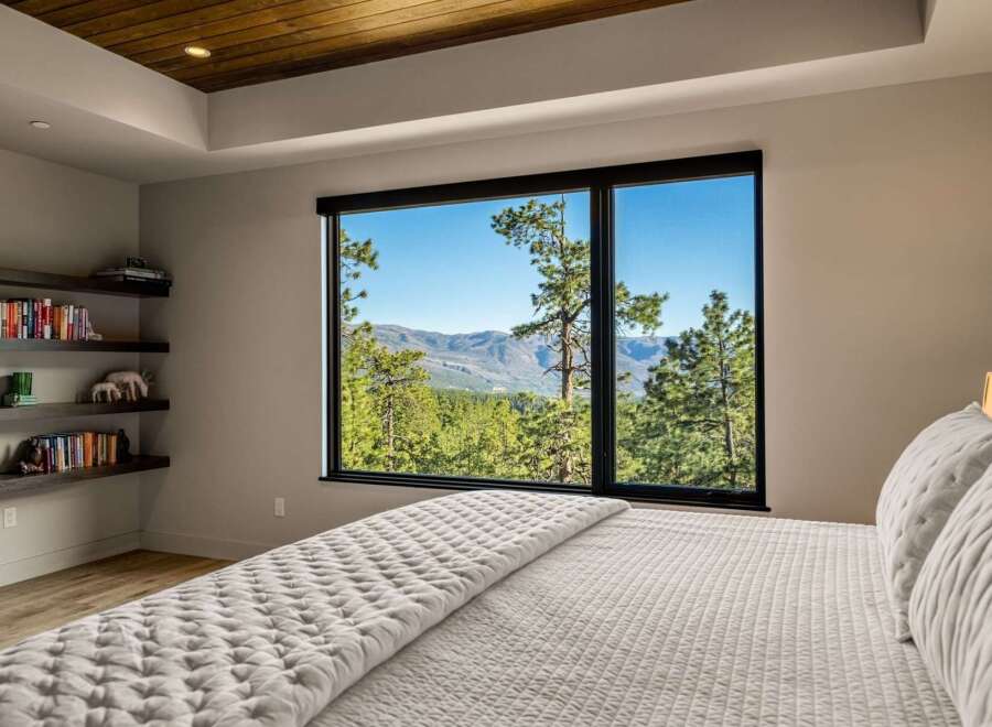 Experience breathtaking mountain views from this serene bedroom, featuring a large picture window that floods the space with natural light.