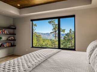 Experience breathtaking mountain views from this serene bedroom, featuring a large picture window that floods the space with natural light.