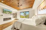 Experience luxury mountain living in this stunning bedroom featuring a modern gas fireplace and a wall-mounted TV for ultimate relaxation.