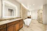 Experience luxury in this stunning master bathroom, featuring a freestanding soaking tub and a spacious glass-enclosed shower with marble tile.