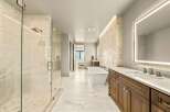 Experience luxury in this stunning master bathroom, featuring a spacious walk-in shower with marble tile and a freestanding soaking tub.