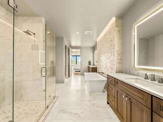 Experience luxury in this stunning master bathroom, featuring a spacious walk-in shower with marble tile and a freestanding soaking tub.