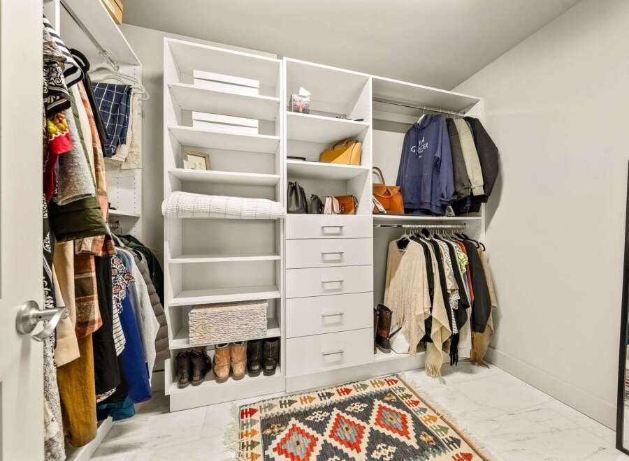 Step into this spacious walk-in closet, designed for ultimate organization and style.