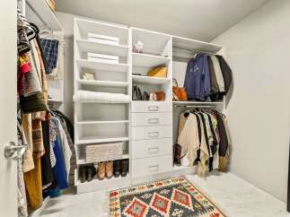 Step into this spacious walk-in closet, designed for ultimate organization and style.