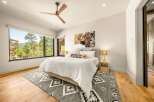 Experience luxury mountain living in this stunning bedroom featuring a king-sized bed adorned with plush white linens and a striking bison artwork above.