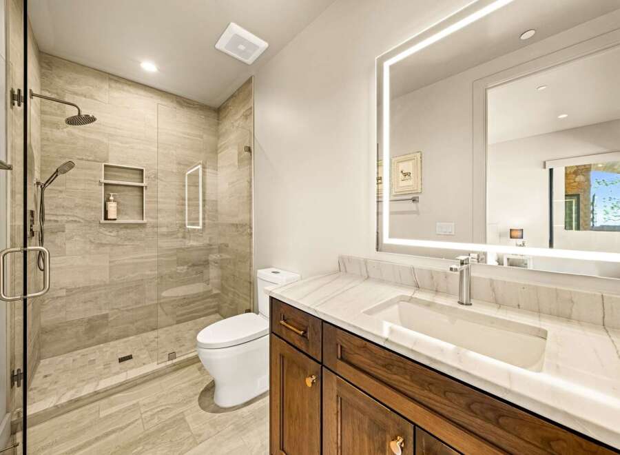 Experience modern luxury in this stunning bathroom, featuring a spacious walk-in shower with elegant tilework and a built-in niche for toiletries.