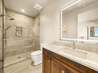 Experience modern luxury in this stunning bathroom, featuring a spacious walk-in shower with elegant tilework and a built-in niche for toiletries.