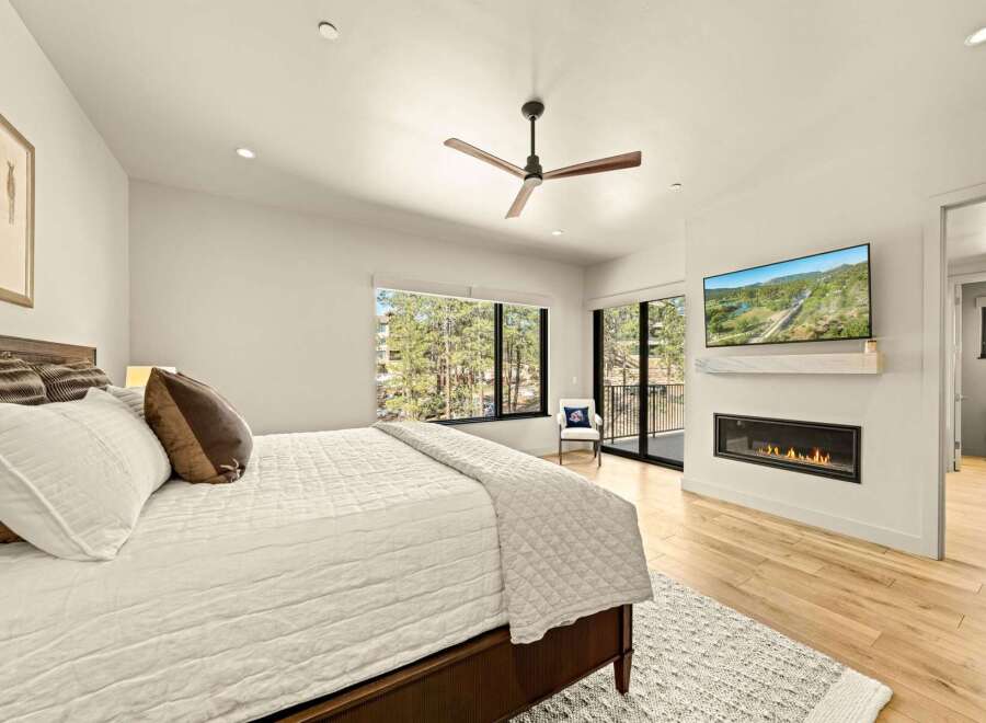 Experience luxury and comfort in this stunning bedroom, featuring a modern gas fireplace and a wall-mounted TV for ultimate relaxation.