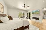 Experience luxury and comfort in this stunning bedroom, featuring a modern gas fireplace and a wall-mounted TV for ultimate relaxation.