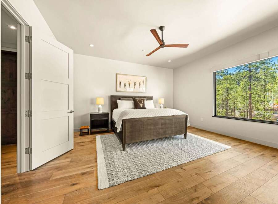 Experience serene living in this beautifully appointed bedroom, featuring a spacious king-size bed and a modern ceiling fan for ultimate comfort.