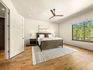 Experience serene living in this beautifully appointed bedroom, featuring a spacious king-size bed and a modern ceiling fan for ultimate comfort.