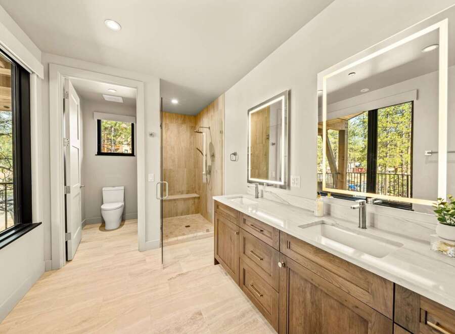 Experience luxury in this modern bathroom featuring a spacious walk-in shower with elegant tilework and a built-in bench.