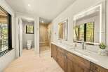 Experience luxury in this modern bathroom featuring a spacious walk-in shower with elegant tilework and a built-in bench.