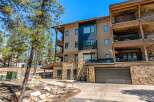 Experience luxury mountain living in this stunning multi-level residence, featuring a modern facade with stone accents and expansive balconies perfect for enjoying the surrounding pine forest.