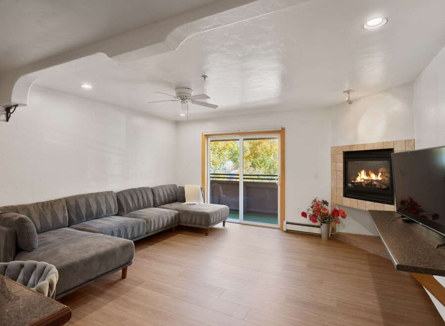 Cozy up by the fireplace in this inviting living room, featuring a spacious sectional sofa perfect for relaxation.