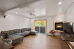 Cozy up by the fireplace in this inviting living room, featuring a spacious sectional sofa perfect for relaxation.