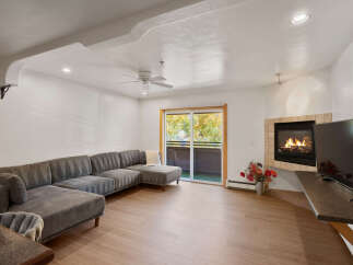 Cozy up by the fireplace in this inviting living room, featuring a spacious sectional sofa perfect for relaxation.
