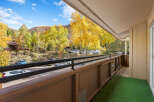 Experience the vibrant beauty of autumn from this charming balcony, offering stunning views of golden aspen trees and rolling hills.