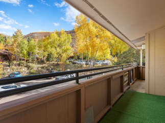 Experience the vibrant beauty of autumn from this charming balcony, offering stunning views of golden aspen trees and rolling hills.