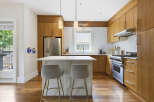 Experience modern living in this stunning kitchen, featuring sleek, warm wood cabinetry and a spacious island perfect for casual dining or entertaining.