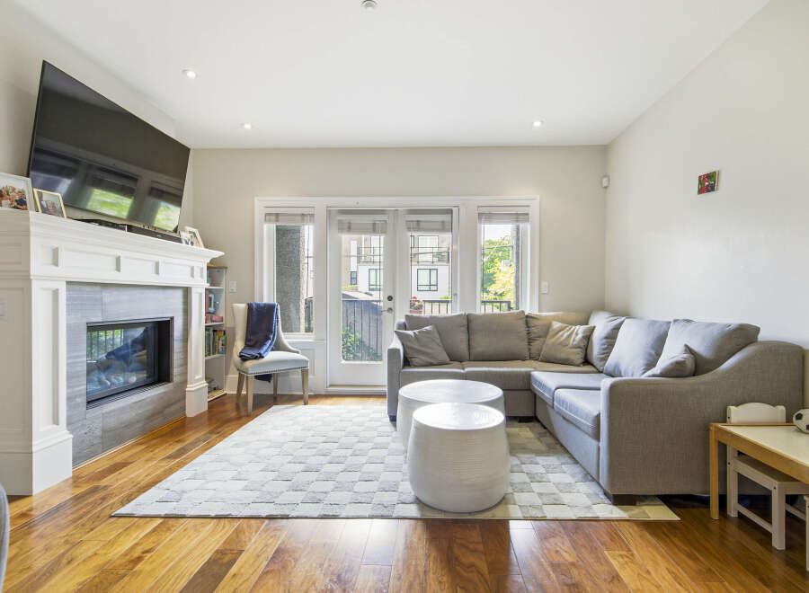 Experience modern living in this inviting living room, featuring a sleek fireplace and a large sectional sofa perfect for relaxation.