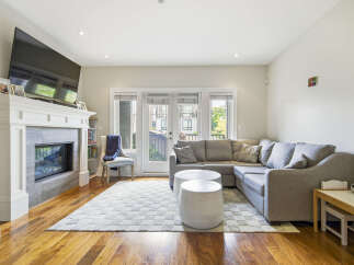 Experience modern living in this inviting living room, featuring a sleek fireplace and a large sectional sofa perfect for relaxation.
