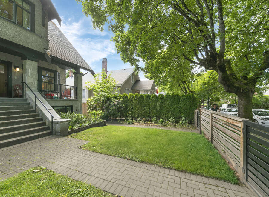 Discover this charming home featuring a welcoming front porch with stone accents and a spacious lawn perfect for outdoor enjoyment.