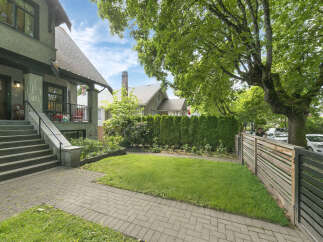 Discover this charming home featuring a welcoming front porch with stone accents and a spacious lawn perfect for outdoor enjoyment.