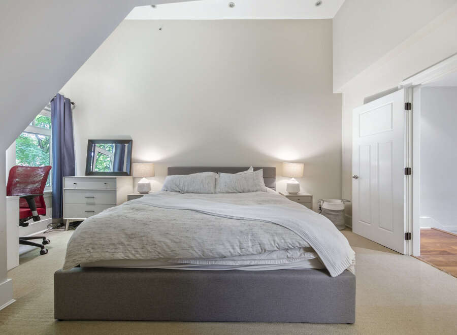 Discover this inviting bedroom featuring a comfortable king-sized bed with a soft, textured duvet and a cozy throw blanket.