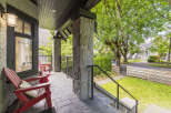 Enjoy relaxing evenings on this charming covered porch, complete with comfortable red Adirondack chairs and a stone-clad pillar.