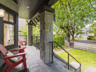 Enjoy relaxing evenings on this charming covered porch, complete with comfortable red Adirondack chairs and a stone-clad pillar.