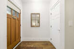 Step into this inviting entryway featuring a warm wooden door with a classic mail slot and a stylish roller shade.