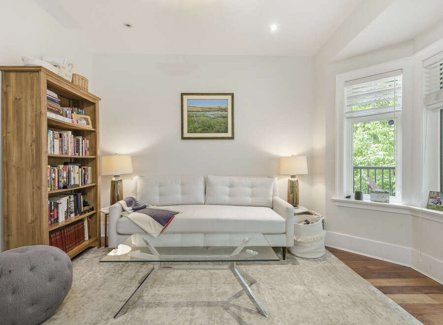 Step into this inviting living room, featuring a plush white sofa perfect for relaxation and a stylish glass coffee table.