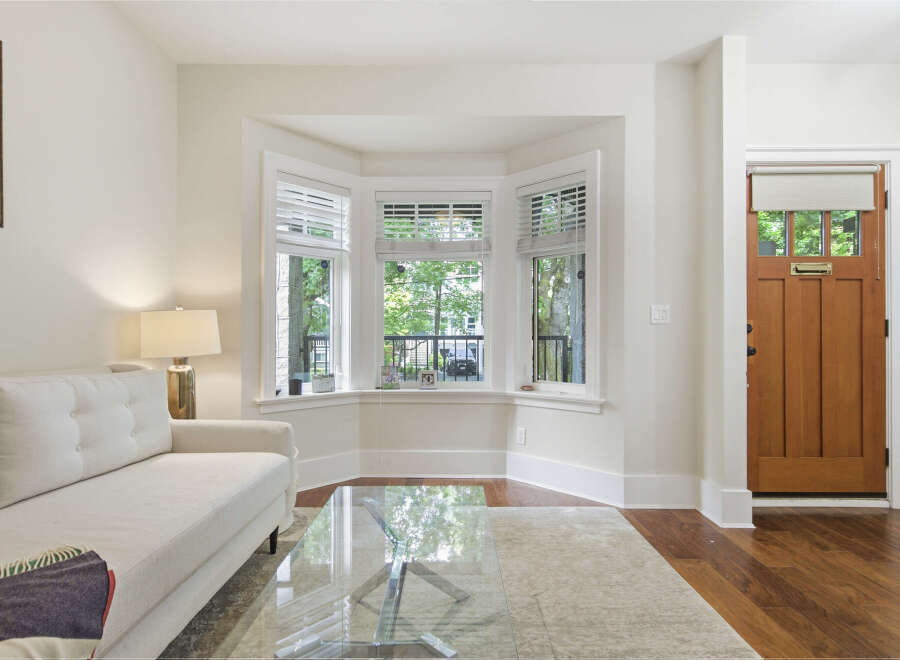 Step into this inviting living space featuring a comfortable white sofa and a sleek glass coffee table, perfect for relaxing or entertaining.