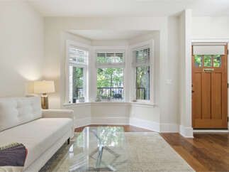 Step into this inviting living space featuring a comfortable white sofa and a sleek glass coffee table, perfect for relaxing or entertaining.