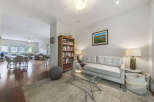 Step into this inviting living space featuring a plush white sofa complemented by a modern glass coffee table and a cozy area rug.