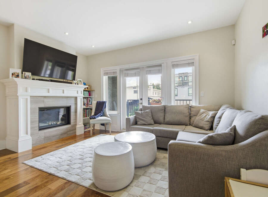 Experience modern living in this beautifully appointed living room, featuring a sleek fireplace and a large sectional sofa perfect for relaxation.