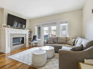 Experience modern living in this beautifully appointed living room, featuring a sleek fireplace and a large sectional sofa perfect for relaxation.