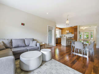 Experience modern living in this open-concept space featuring a comfortable sectional sofa and a sleek dining area.