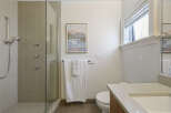 This modern bathroom features a sleek glass-enclosed shower with multiple showerheads and elegant tilework.