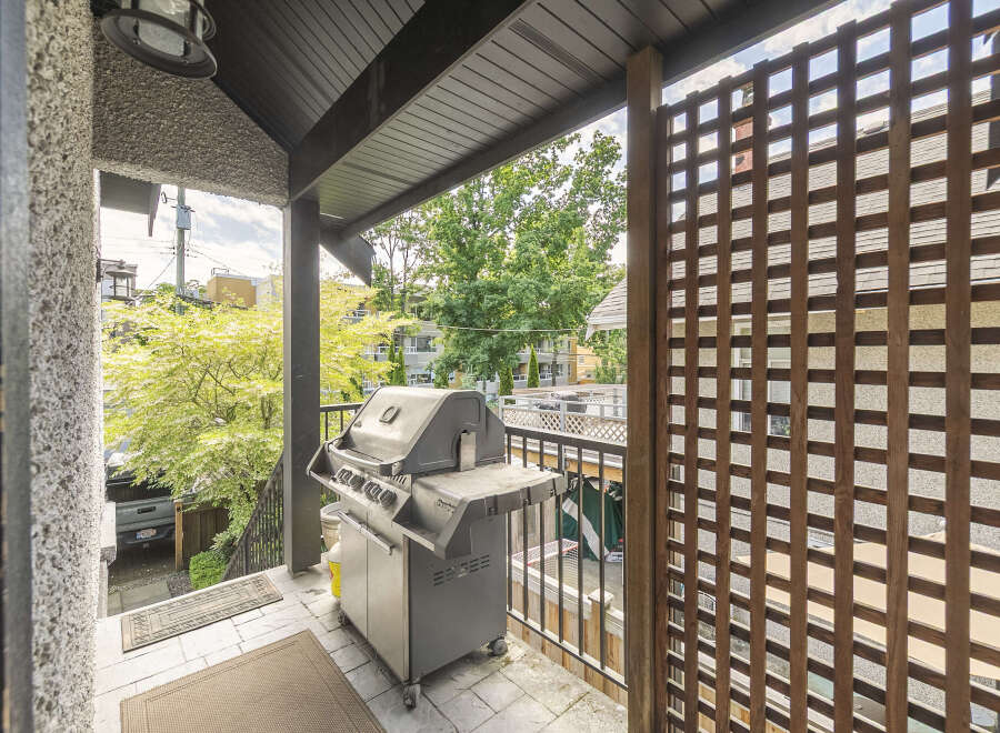 Enjoy outdoor living on this spacious balcony, perfect for entertaining with a built-in grill and ample seating space.