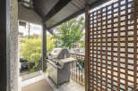 Enjoy outdoor living on this spacious balcony, perfect for entertaining with a built-in grill and ample seating space.